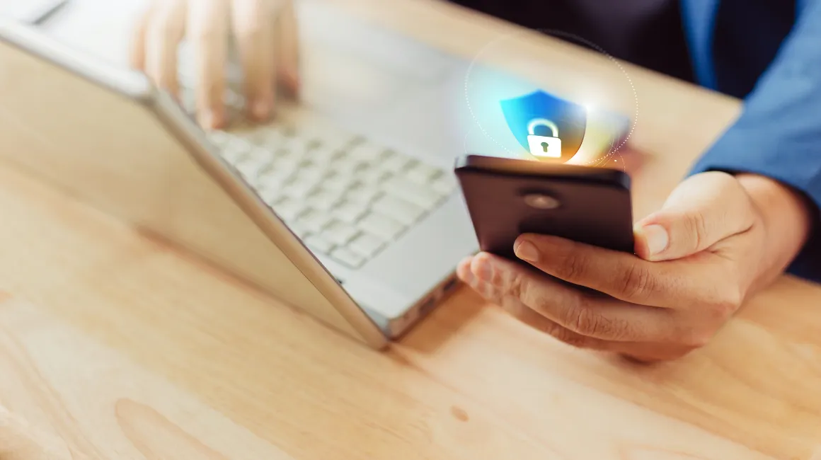 Mężczyzna trzymający telefon z ikoną zabezpieczeń